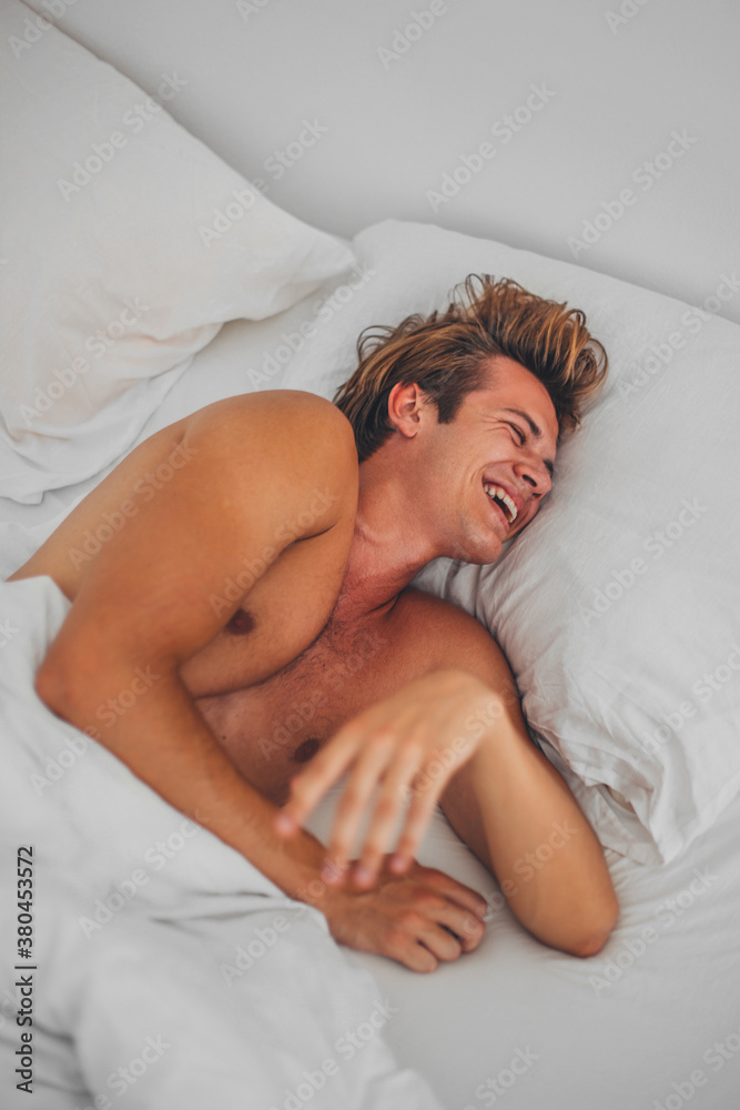 Young Man laughing in the bed. Young Man laughing in the bed.
