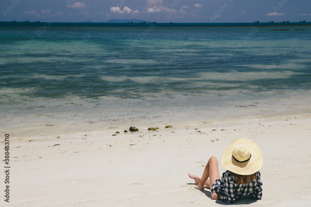Woman dressed in a checkered shirt lying on the beach Woman dressed in a checkered shirt lying on the beach