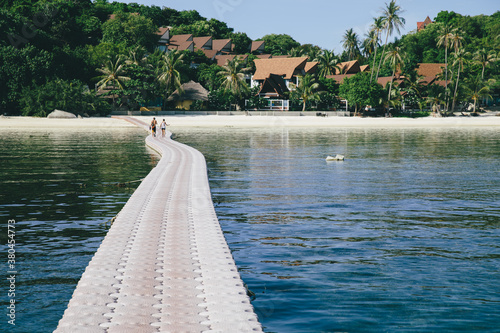 Couple walking at pier in tropics photo