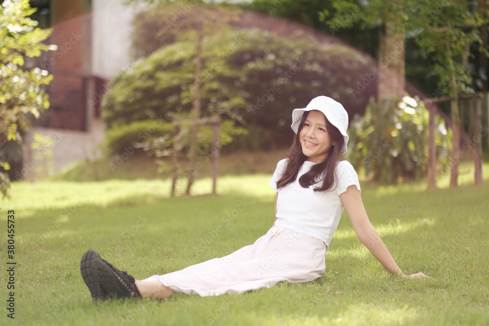 Asian girl sitting on the glass garden, relax and smiling Asian girl sitting on the glass garden, relax and smiling