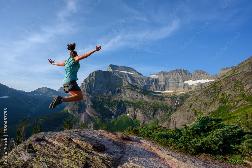 Woman Leaps With View of Grinnell Glacier