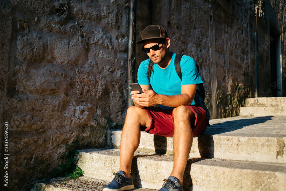 Hip young man working on his mobile phone Hip young man working on his mobile phone