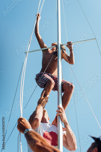 Sailors setting up a sail on the boat