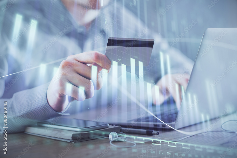 Double exposure of man hands holding a credit card and Forex graph drawing. Stock trading and digital fintech in Internet E-commerce concept. Double exposure of man hands holding a credit card and Forex graph drawing. Stock trading and digital fintech in Internet E-commerce concept.