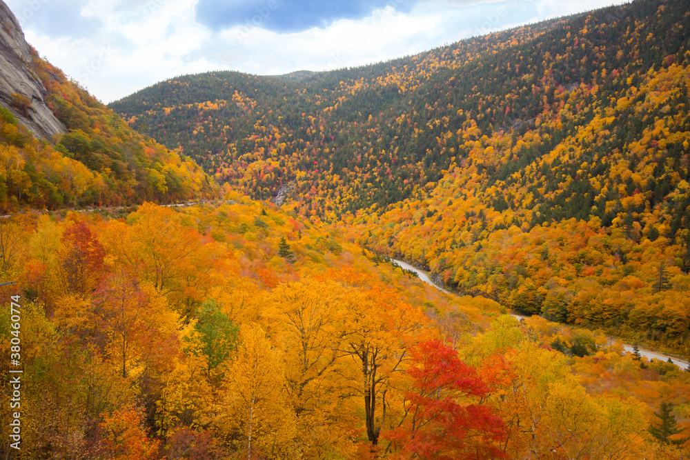 View of the White Mountain National Forest and Craford Notch Road just west of Bartlett, New Hampshire. Hardwood trees are showing peak fall color. View of the White Mountain National Forest and Craford Notch Road just west of Bartlett, New Hampshire. Hardwood trees are showing peak fall color.