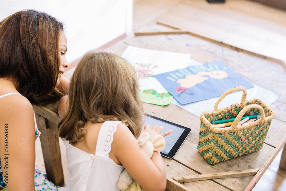 mother and daughter using a digital tablet mother and daughter using a digital tablet
