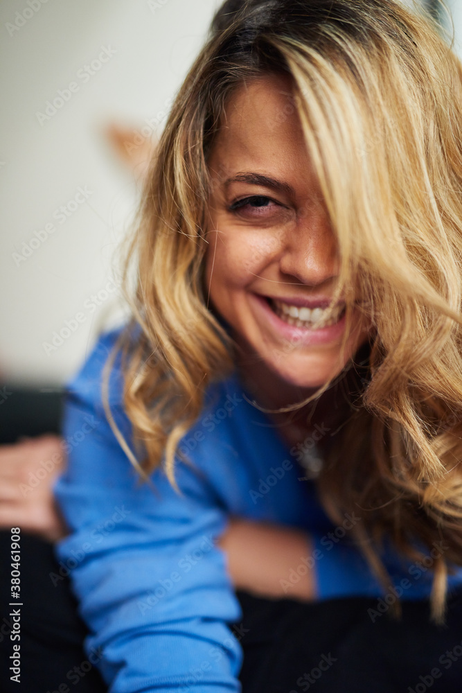 smiling blonde woman lying on bed