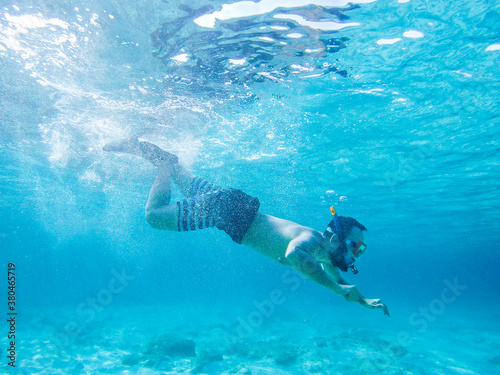 Young man diving in crystal clear waters