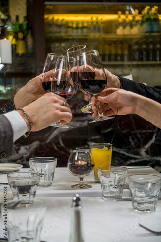 Four friends toasting with wine at high class restaurant