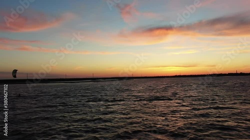Aerial footage of a kitesurfer riding the wind during the sunset, 4k
