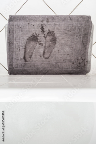 Looking down on wet footprints on a bath mat photo