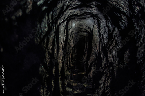 A dark and intimidating cave leading into a ominous hole