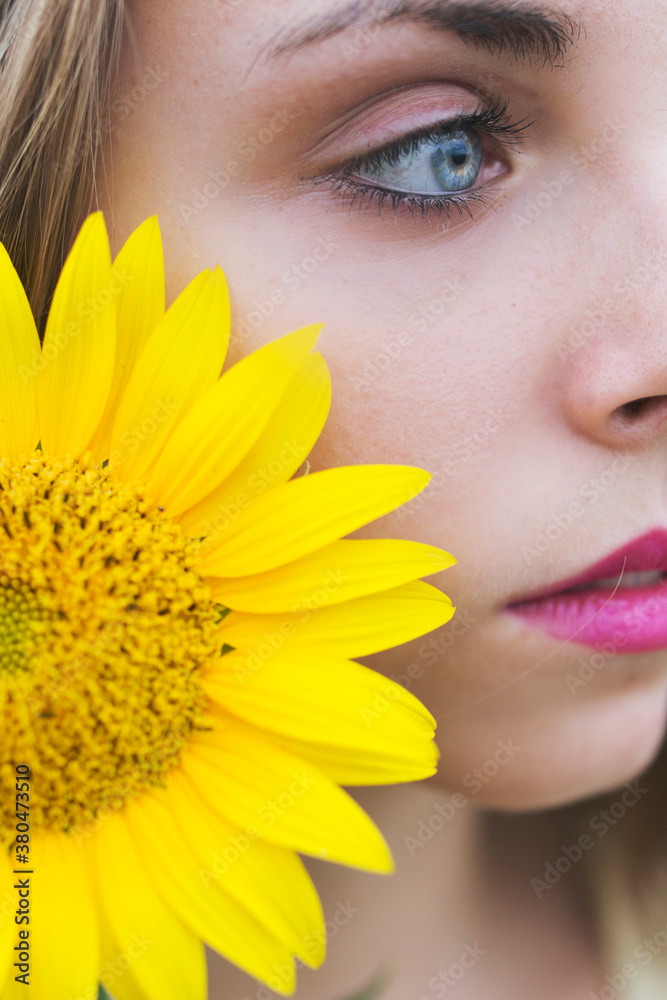 Young woman and sunflower close up
