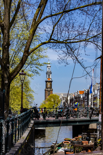 Photography Peekaboo View of the Steeple of Westerkerk from the Canals in Amsterdam, Netherl