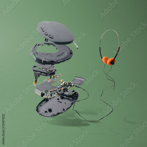 Disassembled Portable CD Player With Headphones On Green Background photo