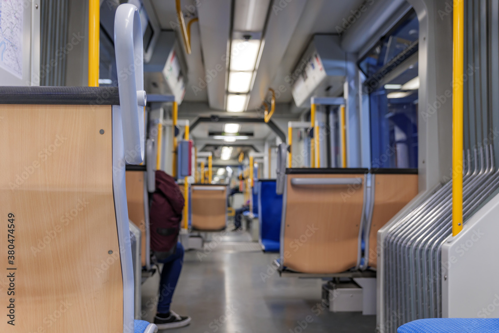 Interior view of a corridor inside passenger trains or light rail tram with blue fabric seats of German railway train system. Empty vacant passenger car inside the train. Interior view of a corridor inside passenger trains or light rail tram with blue fabric seats of German railway train system. Empty vacant passenger car inside the train.