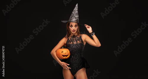 Halloween sexy witch girl with pumpkin.