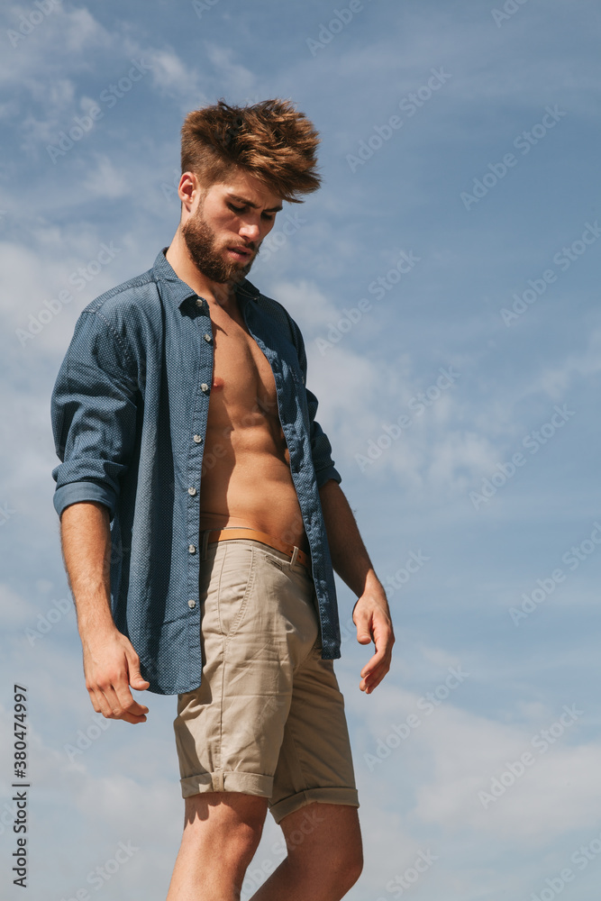 Young Man with Summer Outfit Against a Radiant Blue Sky