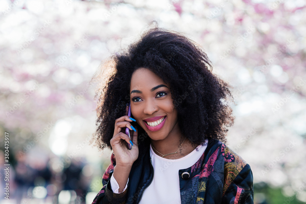 Young black woman smiling while talking on the phone