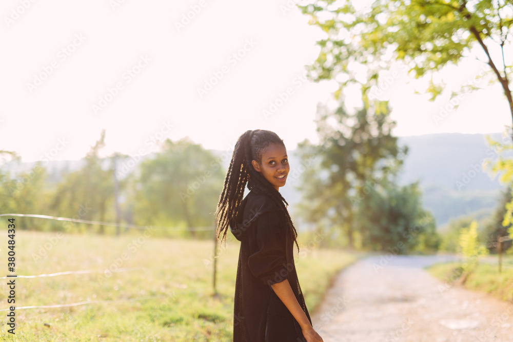 Rasta woman with dreadlocks posing in the nature at sunset Rasta woman with dreadlocks posing in the nature at sunset