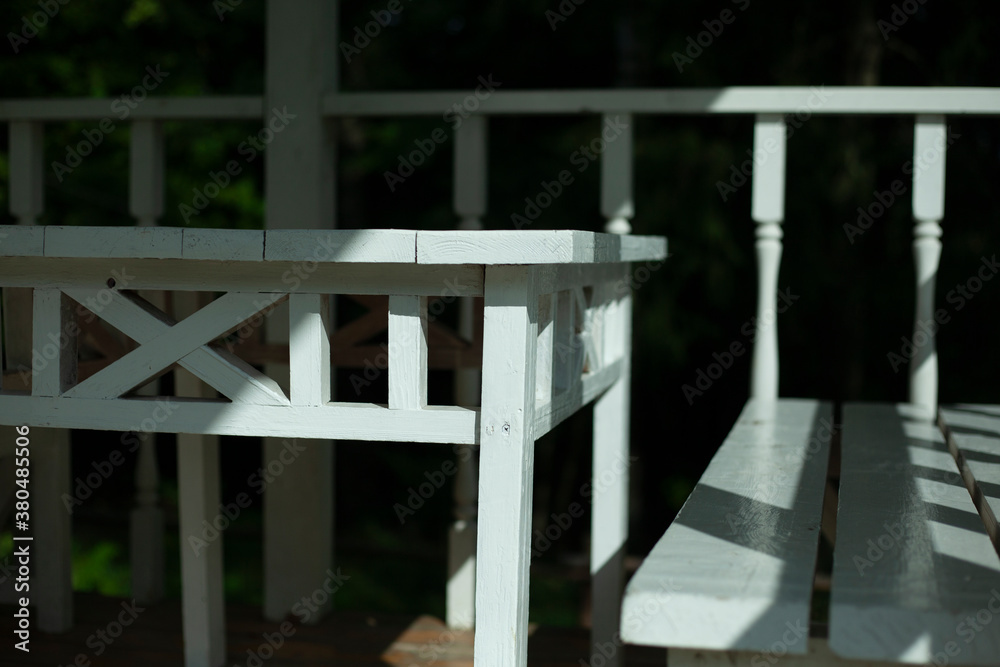 White table and bench on the summer veranda. Wooden furniture. Stylist of the 19th century.