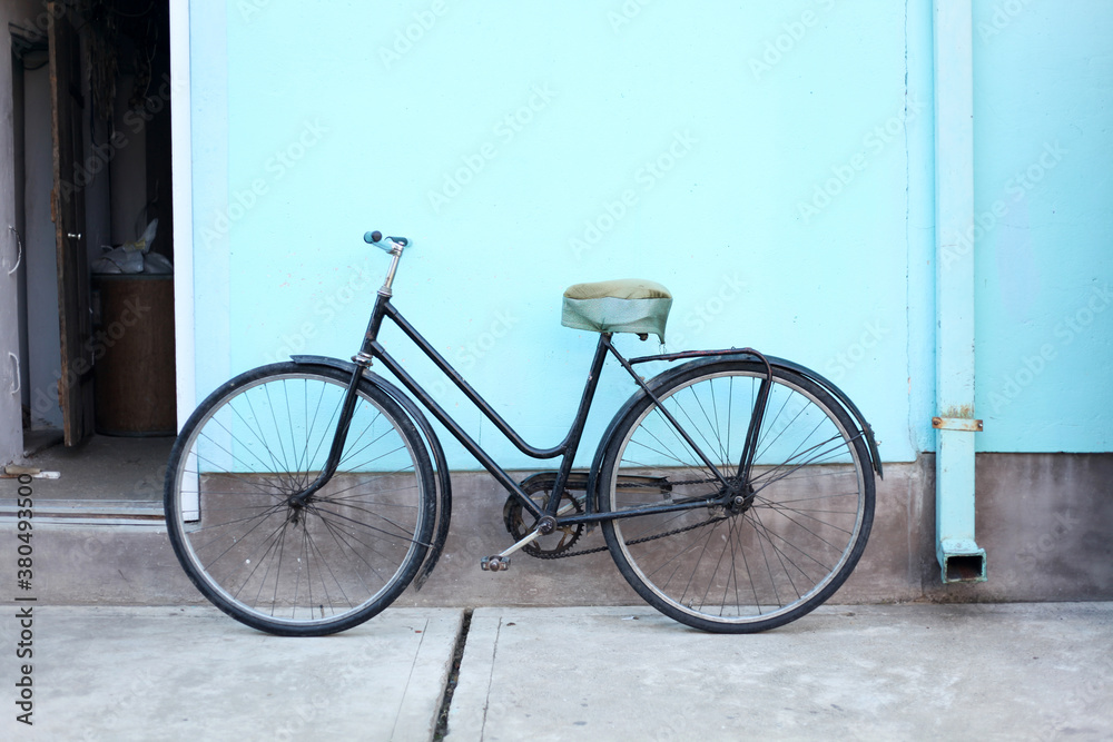 Old bicycle in front of a blue wall Old bicycle in front of a blue wall