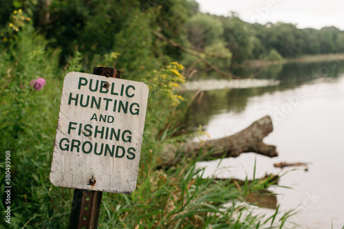 Hunting and fishing groungs public sign by a lake