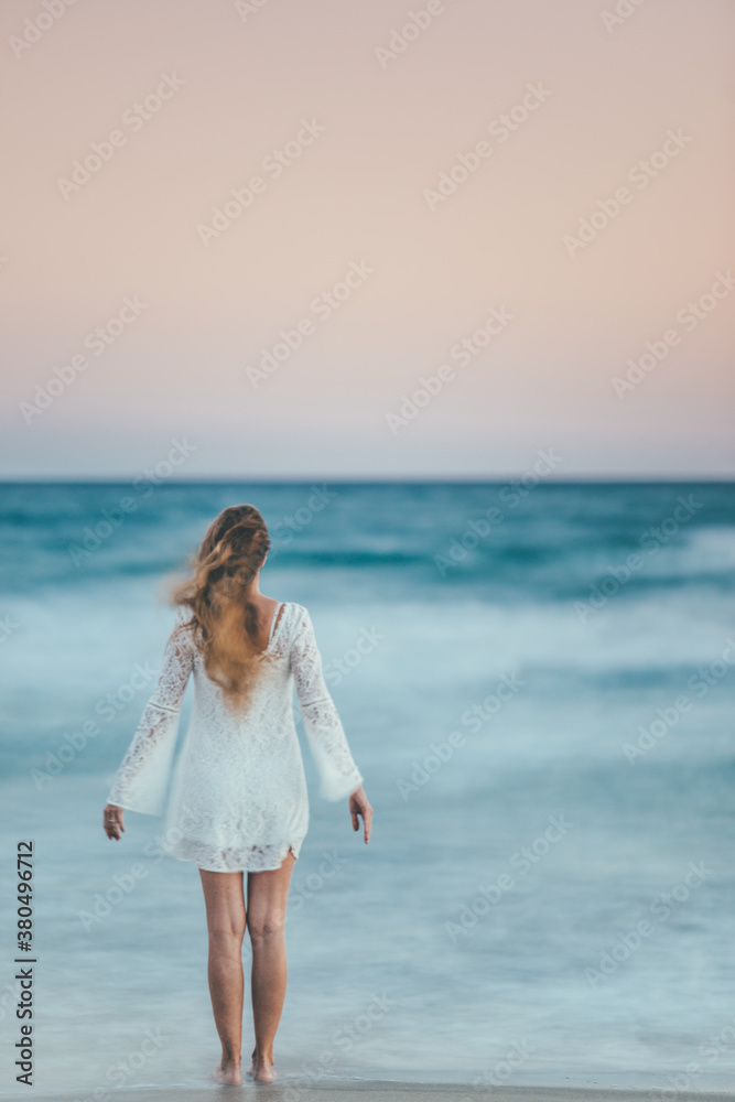 woman enjoying the sunset on the beach woman enjoying the sunset on the beach