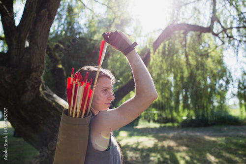 Side view of woman taking an arrow from the quiver