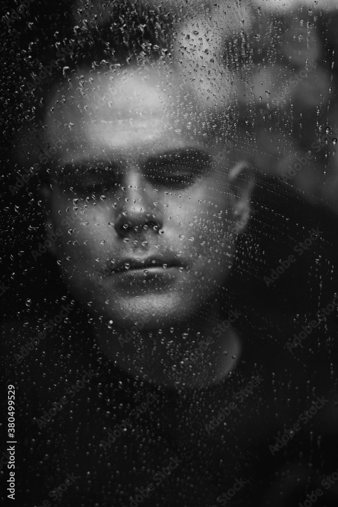 Portrait of a man watching rain through window Portrait of a man watching rain through window