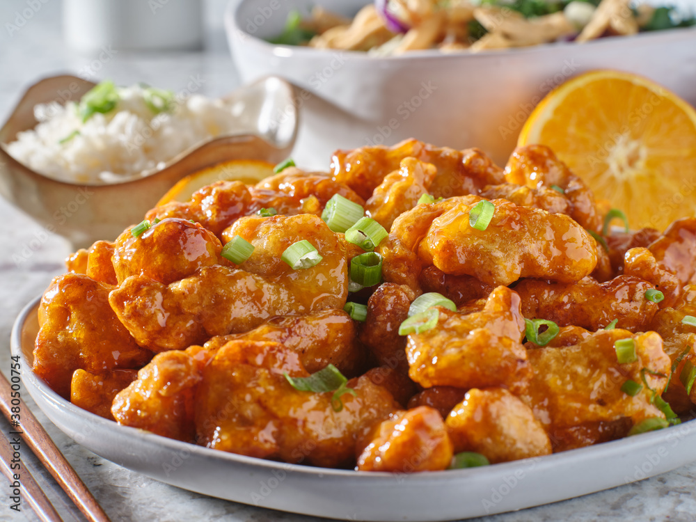 plate of chinese orange chicken with green onion garnish plate of chinese orange chicken with green onion garnish