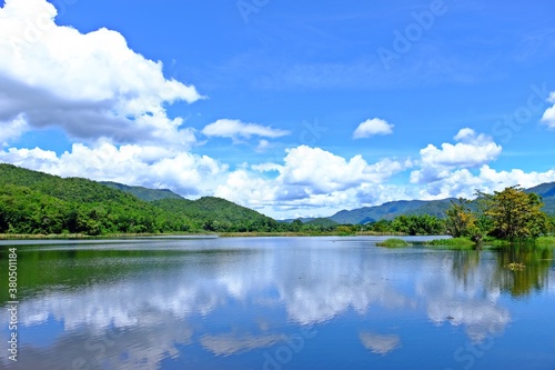 Beautiful lake with green mountain, blue sky, white cloud and the reflection on the water.