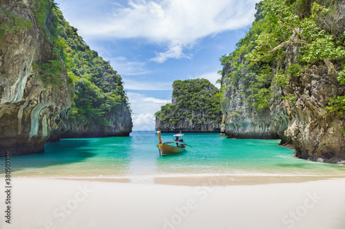 Thai traditional wooden longtail boat and beautiful beach. © gamjai