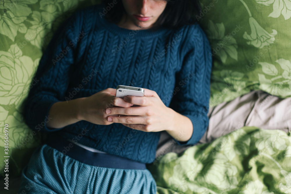 Woman browsing on her mobile phone and lying in the bed Woman browsing on her mobile phone and lying in the bed