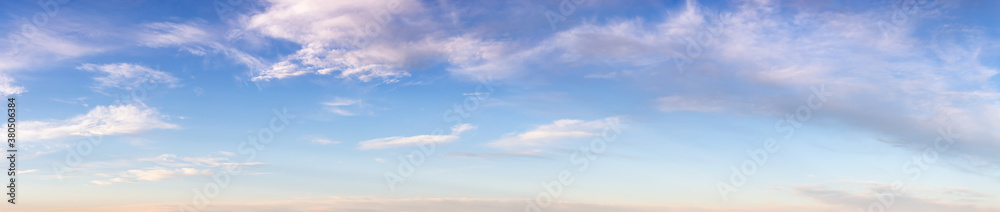 Beautiful Panoramic View of Puffy White Clouds with blue Sky in Background during a sunny summer sunrise. Taken in Yukon, Canada.
