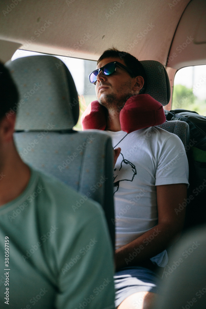 Young man sleeping comfortably in the back of a van during a road trip Young man sleeping comfortably in the back of a van during a road trip