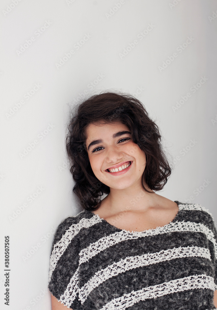 Portrait of young smiling woman leaning on a wall. Portrait of young smiling woman leaning on a wall.