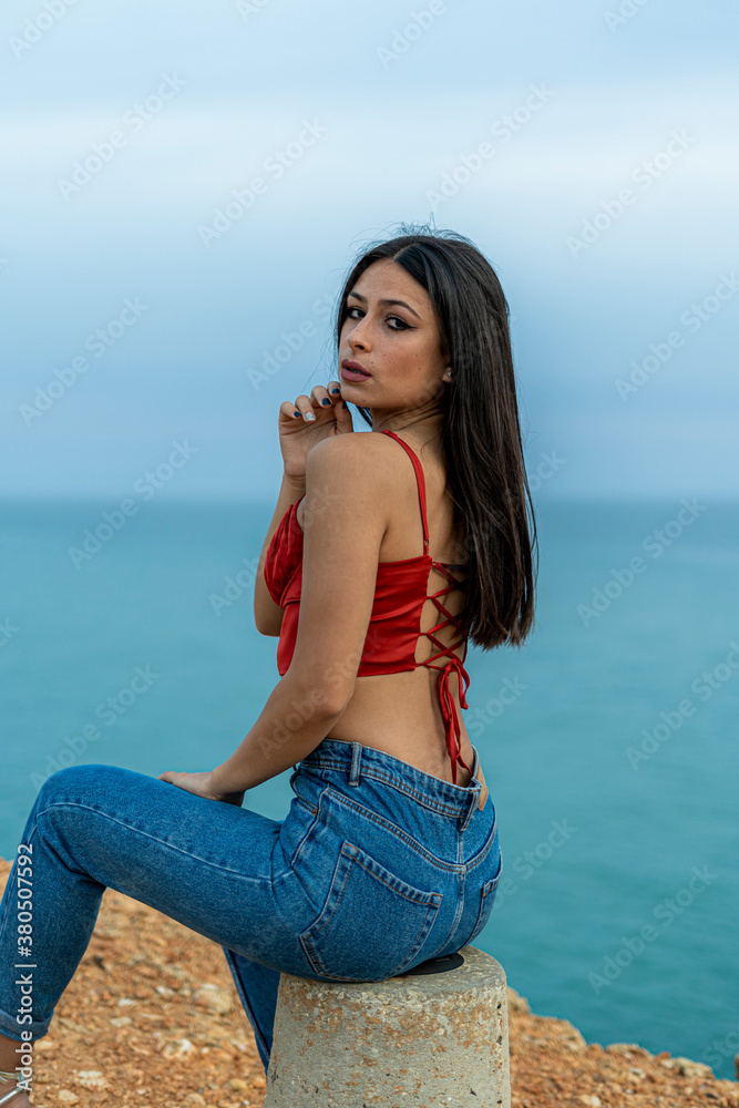 Mujer joven adolescente modelo posando en un acantilado y en la playa. Chica vestida elegante para modelo Stock Photo Adobe Stock