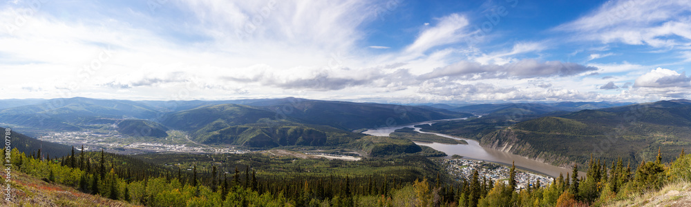 Panoramic View of a Small Touristic Town, Dawson City, from the top of the mountain during a sunny and cloudy summer day. Yukon, Canada. Nature Background Panorama Panoramic View of a Small Touristic Town, Dawson City, from the top of the mountain during a sunny and cloudy summer day. Yukon, Canada. Nature Background Panorama