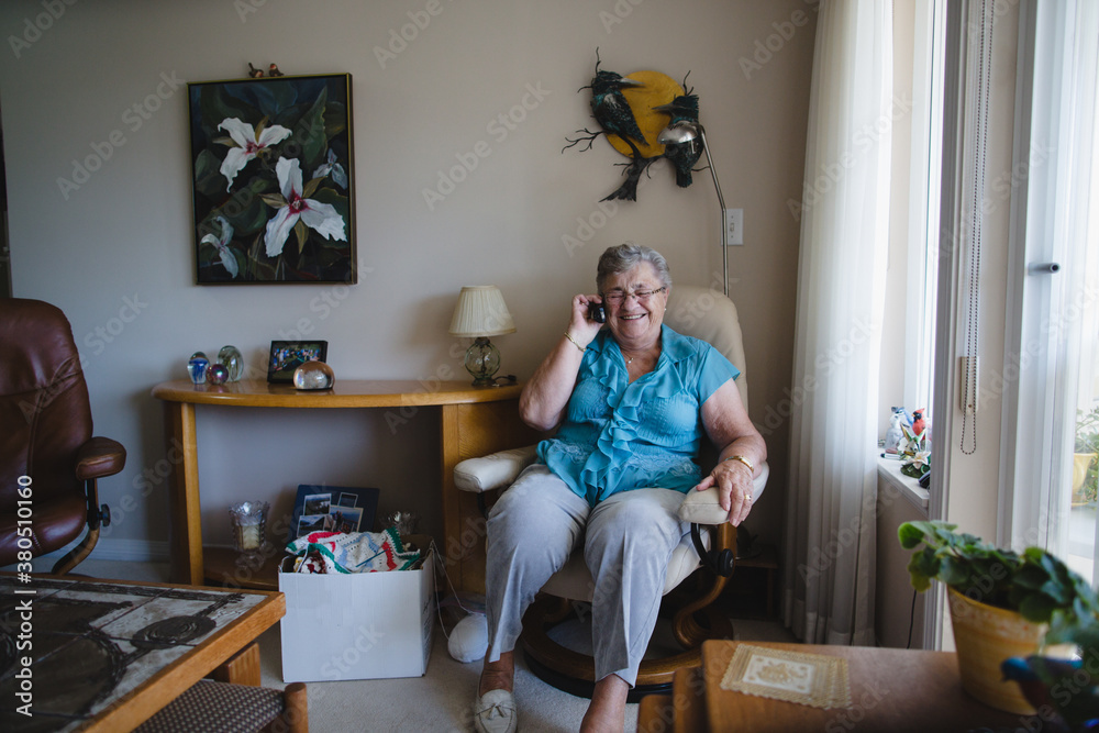 Happy older woman talking on landline phone at home Happy older woman talking on landline phone at home