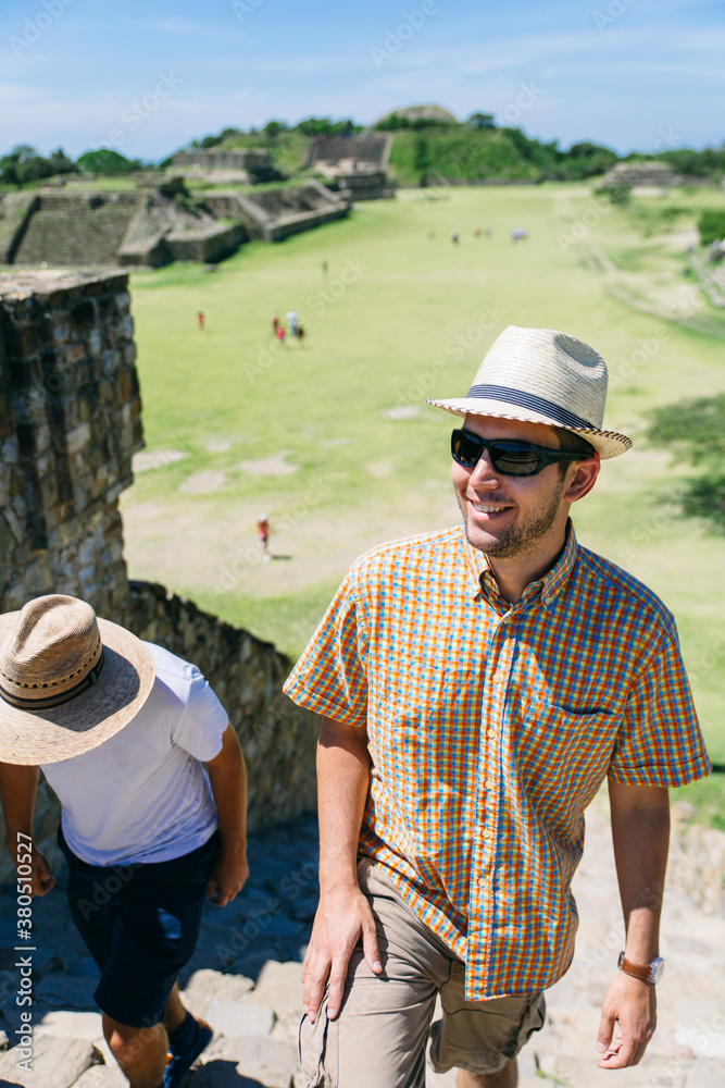 Two young men travelers walking up some steps of ancient ruins landmark in Mexico Two young men travelers walking up some steps of ancient ruins landmark in Mexico