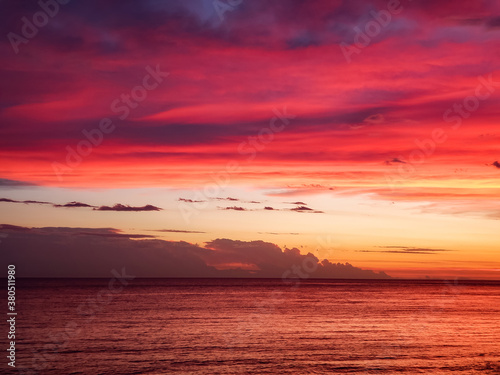 Beautiful sunset at sea with the horizon and purple and reddish hues