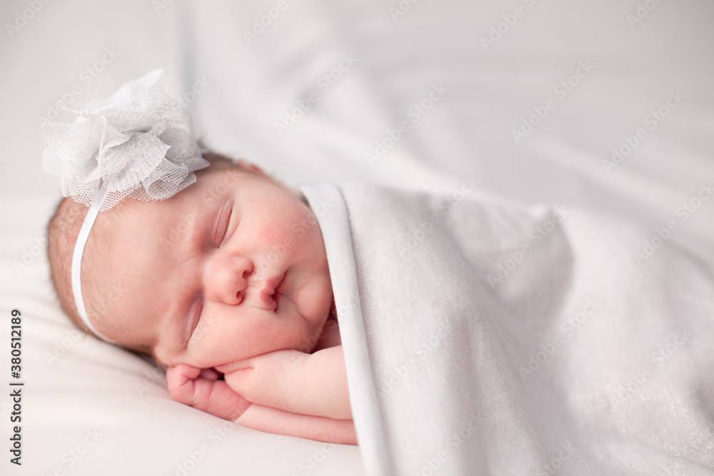 Newborn Baby Girl Sleeping Peacefully Under Blanket, Wearing Flower Headband Newborn Baby Girl Sleeping Peacefully Under Blanket, Wearing Flower Headband