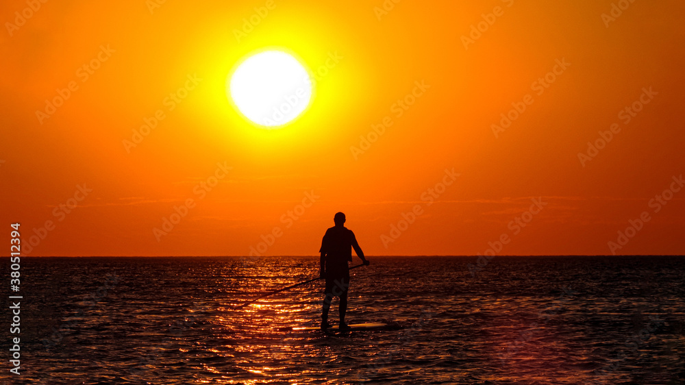 Silhouette of man in the sea at sunset