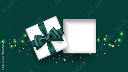 White open square gift box decorated with bow-ribbon green. Light and confetti on green background. Top view. Vector illustration.