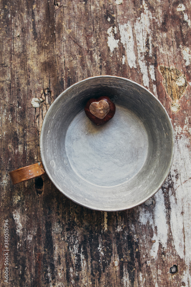 Heart shaped chestnut on a cracked wood table Heart shaped chestnut on a cracked wood table