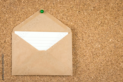 Craft envelope is pinned to a cork board, in the envelope a white lined sheet of paper - an empty place