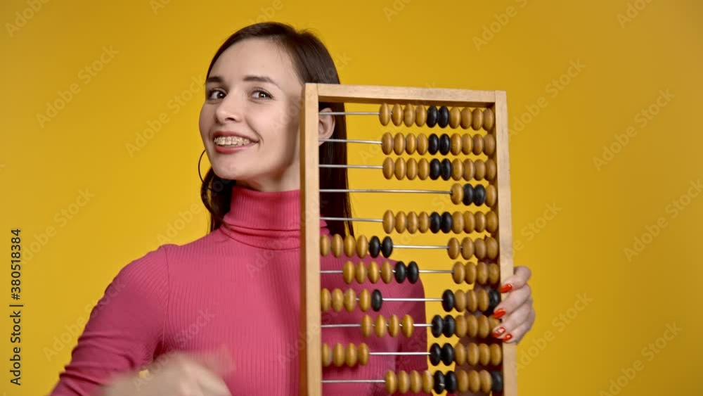Young attractive girl holds wooden abacus in her hands.