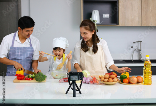 Happy family cooking together on kitchen,Happy family with little chef cooking indoor with live streaming online