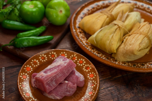 Tamales mexicanos hoja de maiz salsa tomatillo verde picantes chile carne de cerdo platillo latino ingredientes envuelto relleno ancestral tradiciones día de muertos candelaria